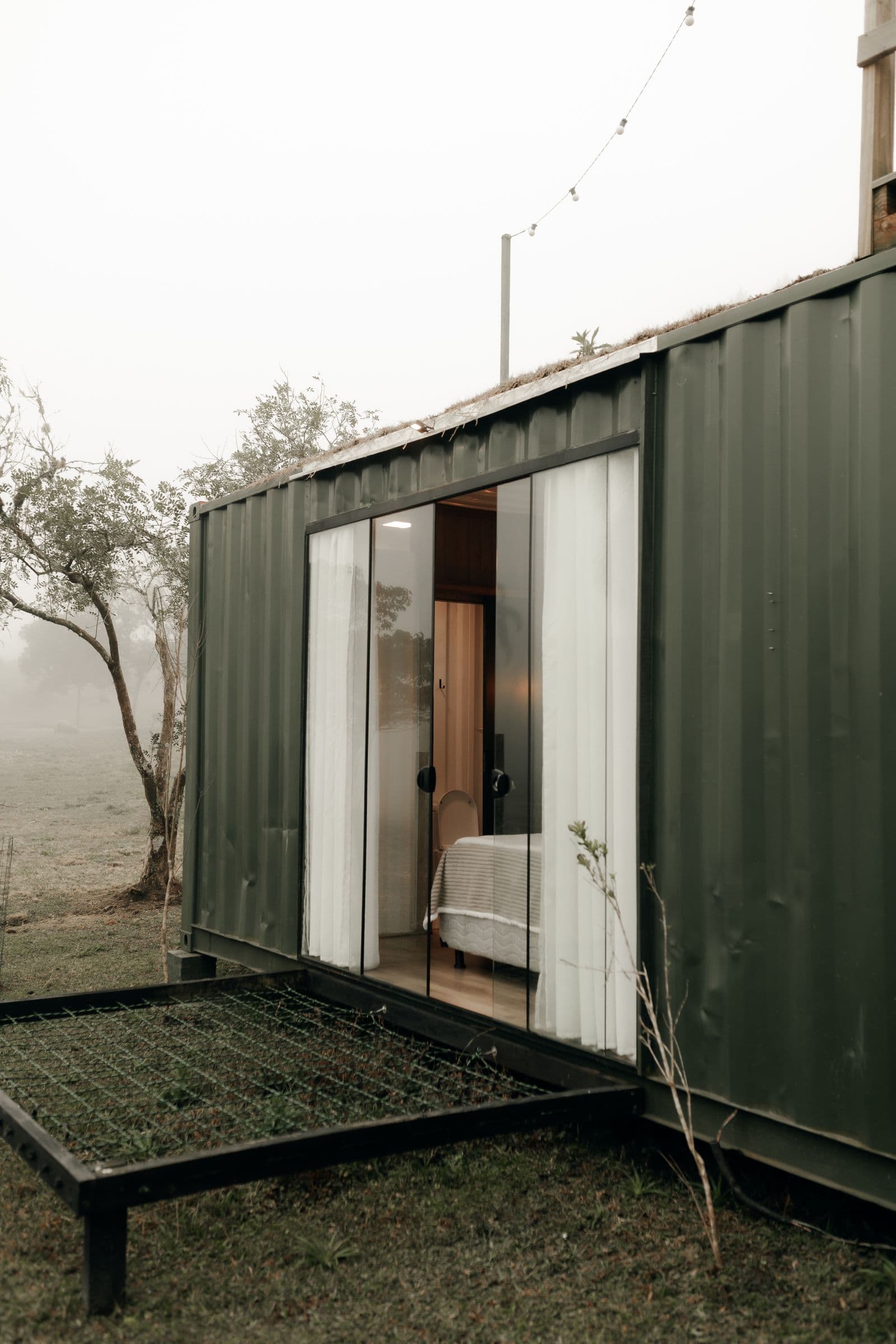 Nhà container hiện đại, cửa kính, đặt giữa rừng